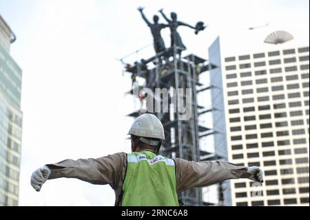 (160324) -- JAKARTA, 24. März 2016 -- Ein Führer der Arbeiter gibt seinen Teamkollegen ein Zeichen während der Installation von Gerüsten um das Selamat Datang Monument oder das Welcome Monument in Jakarta, Indonesien, am 24. März 2016. Die Installation von Gerüsten, die so hoch wie die Statue Selamat Datang sind, in Indonesia Hotel Fountain soll die Stabilität der Statue vor den Vibrationen bewahren, die durch unterirdische Spurbohrungen während des Projekts Mass Rapid Transit (MRT) verursacht werden. Das MRT-Projekt ist ein Massengütertransport, der das Zentrum von Jakarta mit den Außenbezirken von Jakarta verbindet. ) INDONESIEN-JAKARTA-INSTALLATION VON SCAFF Stockfoto