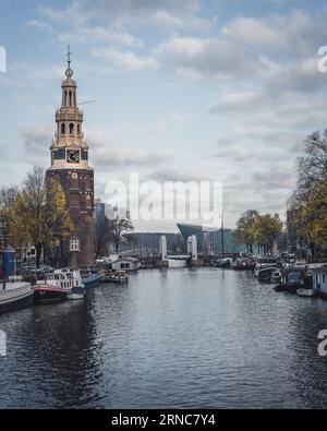 Amsterdam, Niederlande - November 28 2022: Montelbaanstoren ist ein herrlicher Herbstnachmittag in Amsterdam unter einem bewölkten blauen Himmel. Stockfoto