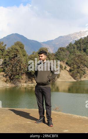 Ein südasiatischer Mann, der an einem See in Deoria Tal Uttarakhand, Indien, steht Stockfoto