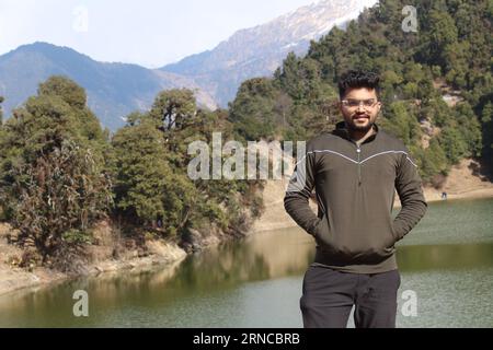 Ein südasiatischer Mann, der an einem See in Deoria Tal Uttarakhand, Indien, steht Stockfoto