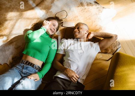 Blick aus einem hohen Winkel auf glückliche Frau und Mann, die zu Hause auf dem Boden liegen Stockfoto