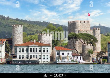 Istanbul, Türkei - 8. Mai 2023: Blick auf die asiatische Seite der Bosporusstraße mit der Burg Anadoluhisari, einer Festung aus dem 14. Jahrhundert mit grünen Bergen im Hintergrund, erbaut vom osmanischen Sultan Bayezid I. Stockfoto