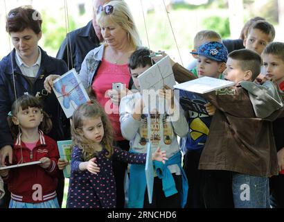 (160412) -- ZAGREB, 12. April 2016 -- Kinder pflücken Bücher, die in Bäumen hängen, während der Eröffnungszeremonie des 9. Kinderbuchfestivals im Tresnjevka-Park in Zagreb, Hauptstadt Kroatiens, 12. April 2016. „Pick a Story“-Veranstaltung wird organisiert, um Lesehandlungen bei Kindern im Vorschulalter zu fördern. ) KROATIEN-ZAGREB-CHILDREN S BOOK FESTIVAL MisoxLisanin PUBLICATIONxNOTxINxCHN 160412 Zagreb 12. April 2016 Kids Pick Books Hanging in Trees während der Eröffnungszeremonie des 9. Children S Book Festivals IM Tresnjevka Park in Zagreb Hauptstadt von Kroatien 12. April 2016 WIRD Pick A Story Event organisiert, um R zu fördern Stockfoto