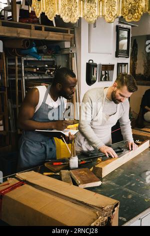 Mehrrassige männliche Unternehmer, die bei Upcycling-Workshops arbeiten Stockfoto