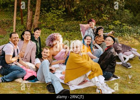 Porträt von multirassischen Freunden aus der LGBTQ-Community, die zusammen im Hinterhof sitzen Stockfoto
