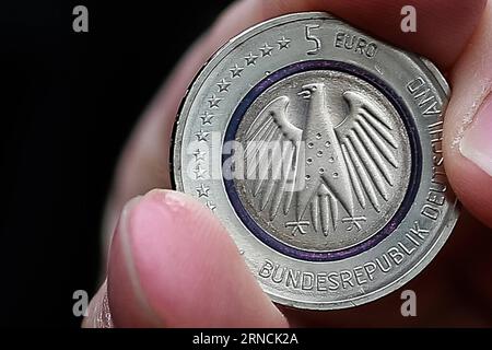 Neue 5-Euro-Münze (160414) -- BERLIN, 14. April 2016 -- Ein Mann stellt seine 5-Euro-Münze am 14. April 2016 vor der Bundesbank aus. Das Bundesfinanzministerium hat am Donnerstag eine neue fünf-Euro-Münze mit neuartigen Merkmalen herausgegeben. Die neue fünf-Euro-Münze konnte nur für Zahlungen in Deutschland verwendet werden. ) DEUTSCHLAND-BERIN-WIRTSCHAFT-FÜNF-EURO-MÜNZE ZhangxFan PUBLICATIONxNOTxINxCHN neue 5-Euro-Münze 160414 Berlin 14. April 2016 ein Mann zeigt seine fünf-Euro-Münze vor der Deutschen Zentralbank AM 14. April 2016 gab das Bundesfinanzministerium AM Donnerstag eine neue fünf-Euro-Münze heraus, die trägt Stockfoto