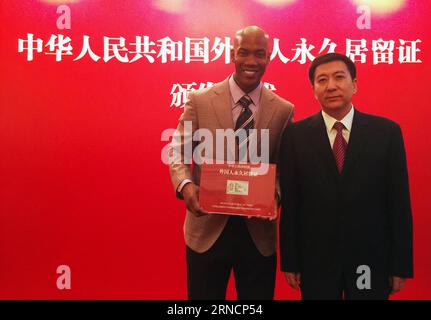 (160418) -- PEKING, 18. April 2016 -- der ehemalige NBA-Star Stephon Marbury (L) posiert mit Zhang Jiandong, stellvertretender Bürgermeister von Peking, während einer Zeremonie in Peking, der Hauptstadt Chinas, am 18. April 2016. Stephon Marbury, ein führender Spieler im Beijing Duck Basketballteam, der dem Team dabei half, drei Champions in der chinesischen Basketballliga zu gewinnen, erhielt am Montag hier seine chinesische grüne Karte oder die permanente Aufenthaltskarte des Ausländers der Volksrepublik China. Marbury verließ die NBA Knicks 2010 und erfand sich in China neu, wo er 2014 zu einem der 10 Model Citizens und Ehrenbürger von BE ernannt wurde Stockfoto