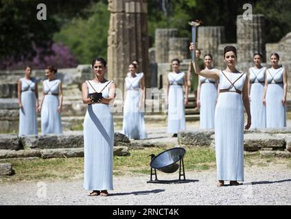 (160420) -- OLYMPIA, 20. April 2016 -- die griechische Schauspielerin Katerina Lehou(R), die die Rolle der Hohepriesterin spielt, zündet einen Kessel mit der Olympischen Flamme während einer Probe für die Flammenbeleuchtung der Olympischen Spiele von Rio 2016 an, am Ort des antiken Olympias, Griechenland, 20. April 2016. Die offizielle Beleuchtungszeremonie für die Olympischen Spiele in Rio findet am 21. April statt. ) (SP)GRIECHENLAND-OLYMPIA-RIO OLYMPICS-FLAMMENBELEUCHTUNG-PROBE JinxYu PUBLICATIONxNOTxINxCHN 160420 Olympia 20. April 2016 griechische Schauspielerin Katerina r spielt die Rolle der Hohepriesterin Lichter ein Kessel mit der Olympischen Flamme während Stockfoto