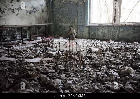 TSCHERNOBYL, 19. April 2016 -- Foto vom 19. April 2016 zeigt eine Puppe mit Gasmaske in einer verlassenen Schule in Pripyat in der Nähe von Tschernobyl, Ukraine. Tschernobyl, ein Ort voller schrecklicher Erinnerungen in der Nordukraine, in der Nähe von Belarus, ist jetzt für Touristen zugänglich, fast 30 Jahre nach der Explosion eines Kernkraftwerks dort. Es war der schlimmste nukleare Unfall in der Geschichte der Menschheit. Ein großer Landstrich um das Werk herum wurde als verbotene Zone ausgewiesen, und gewöhnliche Menschen durften nach der Katastrophe am 26. April 1986 nicht betreten. Der Unfall hat mehr als 8 ausgelöst Stockfoto