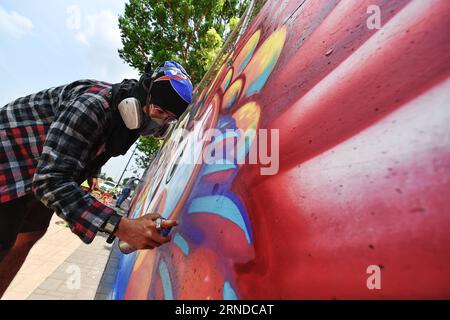 (160515) -- NAKHON SAWAN, 15. Mai 2016 -- Ein Straßenkünstler spritzt am 15. Mai 2016 Farbe auf seine Graffiti-Arbeit außerhalb einer lokalen Abwasserbehandlungsanlage in der Stadt Nakhon Sawan in Zentralthailand. Mehr als sechzig Straßenkünstler aus ganz Thailand wurden vom 13. Bis 15. Mai von der Stadtverwaltung zum Nakhon Sawan Street Art Project eingeladen. Innerhalb von drei Tagen ist es den Künstlern gelungen, die leeren Außenwände einer lokalen Abwasserbehandlungsanlage in eine Graffiti-Galerie zu verwandeln, die sich über etwa vierhundert Meter erstreckt.) THAILAND-NAKHON SAWAN-POP KULTUR-STREET ART-GRAFFITI Stockfoto