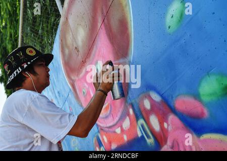 (160515) -- NAKHON SAWAN, 15. Mai 2016 -- Ein Straßenkünstler spritzt am 15. Mai 2016 Farbe auf seine Graffiti-Arbeit außerhalb einer lokalen Abwasserbehandlungsanlage in der Stadt Nakhon Sawan in Zentralthailand. Mehr als sechzig Straßenkünstler aus ganz Thailand wurden vom 13. Bis 15. Mai von der Stadtverwaltung zum Nakhon Sawan Street Art Project eingeladen. Innerhalb von drei Tagen ist es den Künstlern gelungen, die leeren Außenwände einer lokalen Abwasserbehandlungsanlage in eine Graffiti-Galerie zu verwandeln, die sich über etwa vierhundert Meter erstreckt.) THAILAND-NAKHON SAWAN-POP KULTUR-STREET ART-GRAFFITI Stockfoto