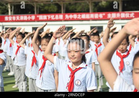HUAI'AN, CHINA - 1. SEPTEMBER 2023 - Grundschullehrer und -Schüler nehmen an der nationalen Flaggenhetzungszeremonie für das neue Semester in Huai'an c Teil Stockfoto