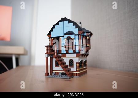 lego mittelalterliches Marktdorf 1601, Eine Person baut ein lego Haus, lego Dorf am Morgen auf dem Tisch. Stockfoto