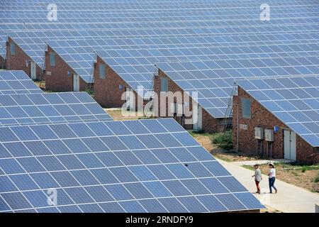 (160519) -- ZHENGZHOU, 19. Mai 2016 -- Bauern gehen durch Gewächshäuser mit Solarpaneeldächern in der Mashang Township des Neihuang County, zentralchinesische Provinz Henan, 19. Mai 2016. In Mashang wurden im Frühjahr insgesamt 772 solcher Gewächshäuser in Betrieb genommen, wo die Einheimischen Pflanzen und bewirtschaften konnten und auch von diesen Solarzellen mit einer jährlichen Stromleistung von 110 Millionen Kilowattstunden profitieren konnten. ) (wyl) CHINA-HENAN-AGRICULTURE-SOLAR GREENHOUSE (CN) ZhuxXiang PUBLICATIONxNOTxINxCHN 160519 Zhengzhou 19. Mai 2016 Bauern gehen durch Grünhäuser mit Sonnenkollektordächern in der Gemeinde NEIHUANG Count Stockfoto