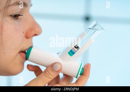 Mädchen verwendet einen medizinischen Inhalator mit Medizin Stockfoto