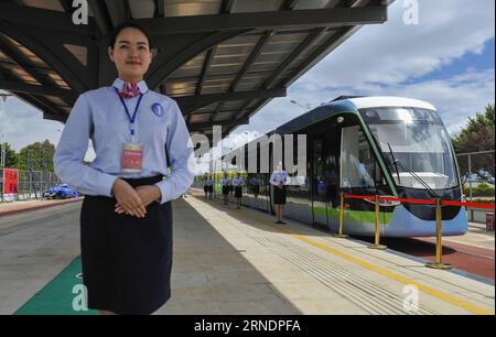 (160527) -- MENGZI, 27. Mai 2016 -- Eine ausgebildete Stewardess steht als experimentelle Straßenbahnzüge in Mengzi, Hani-Yi Autonome Präfektur Honghe in der südwestchinesischen Provinz Yunnan, 27. Mai 2016. Mit einer Investition von 6,619 Milliarden Yuan (etwa 1,009 Milliarden US-Dollar) sind vier Straßenbahnlinien über 62 Kilometer im Bau und werden voraussichtlich 2017 experimentell in Betrieb genommen. ) (zhs) CHINA-YUNNAN-HONGHE-TRAM-CONSTRUCTION (CN) ZhouxLei PUBLICATIONxNOTxINxCHN 160527 Mencius Mai 27 2016 eine ausgebildete Stewardess steht in der autonomen Präfektur Mencius Hani Yi zu Experimentellen Tram-Moves Stockfoto