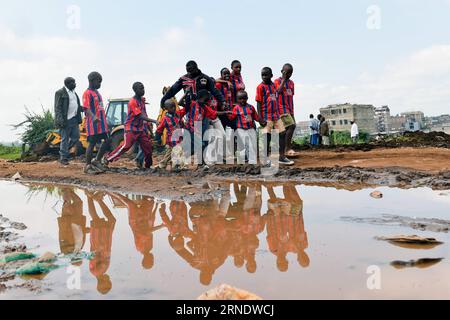 (160531) -- NAIROBI, 31. Mai 2016 -- Foto aufgenommen am 26. Mai 2016 zeigt Dominic Senerwa (C), wie er Kinder zum Sejorooney Kids Talent Center in den Mathare Slums in Nairobi, Kenia führt. Als das kenianische Duo Dominic Senerwa und Joseph Mwangi ein stillgelegtes Gebäude an der örtlichen Polizeiwache in Mathare Slums in Nairobi für philanthropische Arbeit erwarb, wussten sie nicht, dass ihr Haustierprojekt realisiert werden würde. Senerwa, 21, und Mwangi, 23, begannen ihre karitative Mission, das Leben von Kindern aus heruntergekommenen Häusern innerhalb der informellen Siedlung umzukehren, nachdem sie im Staub aufgewachsen waren Stockfoto