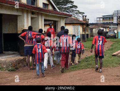 (160531) -- NAIROBI, 31. Mai 2016 -- Foto aufgenommen am 26. Mai 2016 zeigt Joseph Mwangi (rot), der am Tor des Sejorooney Kids Talent Center in den Mathare Slums in Nairobi, Kenia, auf Kinder wartet. Als das kenianische Duo Dominic Senerwa und Joseph Mwangi ein stillgelegtes Gebäude an der örtlichen Polizeiwache in Mathare Slums in Nairobi für philanthropische Arbeit erwarb, wussten sie nicht, dass ihr Haustierprojekt realisiert werden würde. Senerwa, 21, und Mwangi, 23, begannen ihre karitative Mission, das Leben von Kindern aus heruntergekommenen Häusern innerhalb der informellen Siedlung umzukehren Stockfoto