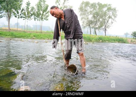 China: blinder und armloser Bauer bestellt gemeinsames Feld SHIJIAZHUANG, 31. Mai 2016 -- Jia Wenqi holt Wasser aus einem Fluss im Yeli Village im Jingxing County, nordchinesische Provinz Hebei, 31. Mai 2016. Der 55-jährige, sehlose Jia Haixia und der 54-jährige, armlose Jia Wenqi verbrachten 14 Jahre damit, ein Ödland in eine Oase zu verwandeln. (Zkr) CHINA-HEBEI-BLIND MAN AND ARMLESS MAN-TREE PLANTING(CN) ZhuxXudong PUBLICATIONxNOTxINxCHN China blind and Armloser Bauer order Common Field Shijiazhuang Mai 31 2016 Jia Wenqi holt Wasser aus einem Fluss im Yeli Village im Jingxing County Nordchina S Hebei Provin Stockfoto