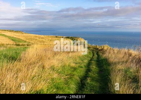 Bempton Cliffs Leute, die auf dem grasbewachsenen Klippenpfad im RSPB Reserve Bempton East Riding an der Yorkshire-Küste England großbritannien und Europa wandern Stockfoto