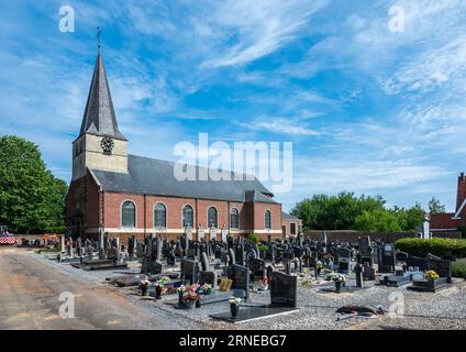 Houwaart, Flandern, Belgien, 14. Juli 2023 - Kirche und Friedhof Saint Denis im Dorfzentrum Stockfoto