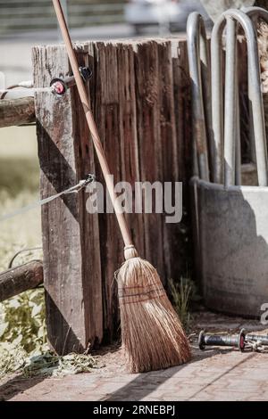 Besen stehen Sie im Hinterhof neben dem Paddock auf Zaun, nachdem Sie den Garten gereinigt und das Haus mit diesem Hexenwerkzeug gepflegt haben Stockfoto