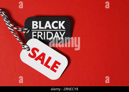 Black friday Sale Thanksgiving Day und Christmas Shopping Konzept mit schwarzem freitag und Verkaufstext auf schwarzem und weißem Papier Preisschilder auf rot. Stockfoto