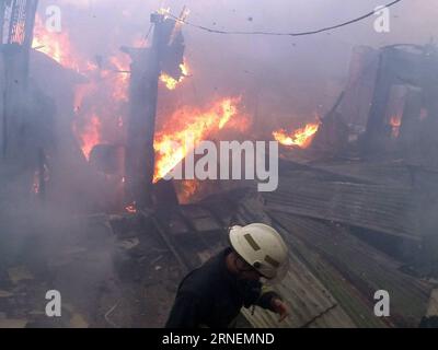 (160628) -- QUEZON CITY, 28. Juni 2016 -- Ein Feuerwehrmann deckt sein Gesicht bei einem Feuerfall in einem Slum-Gebiet, Quezon City, Philippinen, 28. Juni 2016. Laut dem philippinischen Bureau of Fire (BFP) wurden mehr als 300 Shanties im Feuer zerstört und 600 Familien obdachlos gemacht. PHILIPPINEN-QUEZON CITY-SLUM AREA-FIRE RouellexUmali PUBLICATIONxNOTxINxCHN 160628 Quezon City Juni 28 2016 ein Feuerwehrmann deckt sein Gesicht BEI einer Brandszene in einem Slum Area Quezon City die Philippinen Juni 28 2016 mehr als 300 Shanties wurden im Feuer zerstört und ließen 600 Familien zu Hause O Stockfoto