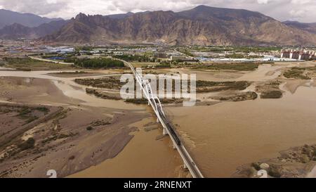 Qinghai-Tibet-Eisenbahn in China (160630) -- LHASA, 30. Juni 2016 -- ein am 20. Juni 2016 aufgenommenes Foto zeigt einen Zug, der auf der großen Brücke des Lhasa entlang der Qinghai-Tibet-Eisenbahn in der südwestchinesischen Autonomen Region Tibet verkehrt. Die Qinghai-Tibet-Eisenbahn wird am 1. Juli 2016 10. Die 1.956 Kilometer lange Eisenbahn, die im Juli 2006 in Betrieb genommen wurde, ist die höchste und längste Plateaubahn der Welt und zugleich die erste Eisenbahn, die die Autonome Region Tibet mit anderen Teilen Chinas verbindet. Umweltschutzmaßnahmen, die während und nach dem Bau der Eisenbahn ergriffen wurden, haben ensu Stockfoto