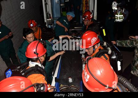 Minenunglück im chinesischen Jincheng (160708) -- QINSHUI, 8. Juli 2016 -- Rettungskräfte tragen einen verletzten Bergmann zu einem Krankenwagen am Standort der Zechenflut in Jincheng, nordchinesische Provinz Shanxi, 8. Juli 2016. Acht Bergleute, die hier mehr als fünf Tage lang in einem überfluteten Kohlebergwerk gefangen waren, wurden am frühen Freitagmorgen aus der Grube gehoben, sagten die lokalen Behörden. Die Überschwemmung ereignete sich in einem Kohlebergwerksschacht in Jincheng City gegen 22:53 Uhr am Samstag, als 94 Menschen in dem Schacht arbeiteten, von denen 82 evakuiert wurden. Zwölf Bergleute wurden nach der Überschwemmung gefangen gehalten. Die acht Bergleute waren es Stockfoto