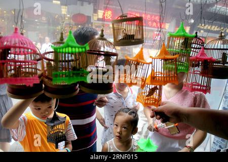 (160709) -- SHANGHAI, 9. Juli 2016 -- Kinder werden von Grillen in winzigen Käfigen angezogen während einer Kulturmesse im Yuyuan Garten der ostchinesischen Gemeinde Shanghai, 9. Juli 2016. Am Samstag fand hier eine Kulturmesse statt, auf der die originalen Bräuche und das Leben des alten Shanghai gezeigt wurden. )(wjq) CHINA-SHANGHAI-YUYUAN GARDEN-FAIR (CN) LiuxYing PUBLICATIONxNOTxINxCHN 160709 Shanghai 9. Juli 2016 Kinder werden von Grillen im winzigen Käfig angezogen während einer Kulturmesse im Yuyuan Garten der ostchinesischen Gemeinde Shanghai 9. Juli 2016 eine Kulturmesse, die auf die Ausstellung der originalen Gebräuche und des Lebens der alten S ausgerichtet ist Stockfoto