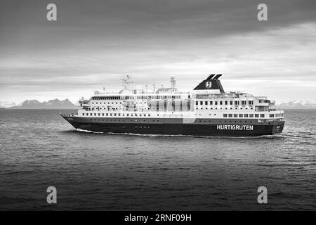 Moody Schwarz-weiß-Foto der norwegischen Hurtigruten-Fähre MS NORDLYS, die in Richtung Norden im Vestfjorden, Nordland, Norwegen segelt. 9. Mai 2023 Stockfoto