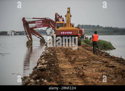 China: Flut bedroht Wuhan (160713) -- WUHAN, 13. Juli 2016 -- bewaffnete Polizeisoldaten bereiten sich auf den Bruch des Damms am Deich des Niushan-Sees in der zentralchinesischen Provinz Hubei vor, 13. Juli 2016. Die Regierung der Provinz Hubei beschloss am Dienstag, den Damm zwischen dem Liangzi Lake und dem Niushan Lake zu brechen, um einen möglichen Überlauf des Deichs zu verhindern. Die Operation wird am 14. Juli durchgeführt. )(wjq) CHINA-HUBEI-LAKE-Flood CONTROL MEASURES (CN) XiaoxYijiu PUBLICATIONxNOTxINxCHN China Flood bedrohte Wuhan 160713 Wuhan 13. Juli 2016 bewaffnete Polizeisoldaten bereiten sich auf den Bruch der Th vor Stockfoto