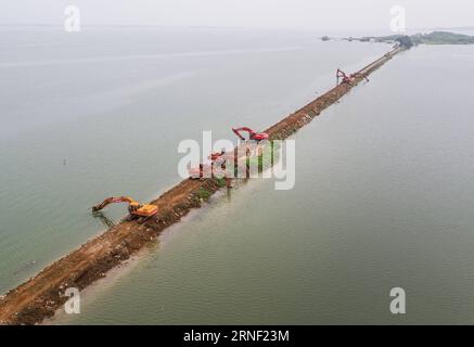 China: Flut bedroht Wuhan (160713) -- WUHAN, 13. Juli 2016 -- bewaffnete Polizeisoldaten bereiten sich auf den Bruch des Damms am Deich des Niushan-Sees in der zentralchinesischen Provinz Hubei vor, 13. Juli 2016. Die Regierung der Provinz Hubei beschloss am Dienstag, den Damm zwischen dem Liangzi Lake und dem Niushan Lake zu brechen, um einen möglichen Überlauf des Deichs zu verhindern. Die Operation wird am 14. Juli durchgeführt. )(wjq) CHINA-HUBEI-LAKE-Flood CONTROL MEASURES (CN) XiaoxYijiu PUBLICATIONxNOTxINxCHN China Flood bedrohte Wuhan 160713 Wuhan 13. Juli 2016 bewaffnete Polizeisoldaten bereiten sich auf den Bruch der Th vor Stockfoto