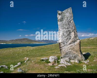 Der 3 m hohe MacLeod's Stone auf der Machair an der Atlantikküste der Insel Harris in den Äußeren Hebriden, Schottland, Großbritannien. Die Insel Taransay kann Stockfoto