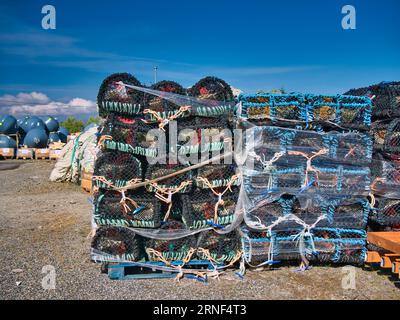 Neue, umwickelte Hummertöpfe oder -Kreolen auf Paletten auf einem Auslieferungsbahnhof auf der Insel Scalpay in den Äußeren Hebriden, Schottland, Großbritannien. An einem sonnigen Tag Stockfoto