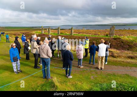 Stromness, Orkney, Schottland, Großbritannien. September 2023. Amerikanische Touristen, die Kreuzfahrtschiffe besuchen, die in Kirkwall anliegen, besuchen den Ring of Brodgar, den neolithischen Steinkreis auf Orkney. Die Einheimischen haben Bedenken geäußert, dass Kreuzfahrtschiffe zu viele Touristen auf die Inseln bringen und die derzeitige Infrastruktur nicht ausreicht. Iain Masterton/Alamy Live News Stockfoto