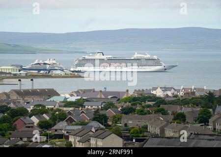 Stromness, Orkney, Schottland, Großbritannien. September 2023. Amerikanische Touristen, die Kreuzfahrtschiffe besuchen, die in Kirkwall anliegen, besuchen den Ring of Brodgar, den neolithischen Steinkreis auf Orkney. Die Einheimischen haben Bedenken geäußert, dass Kreuzfahrtschiffe zu viele Touristen auf die Inseln bringen und die derzeitige Infrastruktur nicht ausreicht. PIC; Kreuzfahrtschiffe im Kirkwall Hafen. Iain Masterton/Alamy Live News Stockfoto