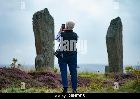 Stromness, Orkney, Schottland, Großbritannien. September 2023. Amerikanische Touristen, die Kreuzfahrtschiffe besuchen, die in Kirkwall anliegen, besuchen den Ring of Brodgar, den neolithischen Steinkreis auf Orkney. Die Einheimischen haben Bedenken geäußert, dass Kreuzfahrtschiffe zu viele Touristen auf die Inseln bringen und die derzeitige Infrastruktur nicht ausreicht. Iain Masterton/Alamy Live News Stockfoto