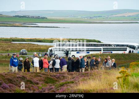 Stromness, Orkney, Schottland, Großbritannien. September 2023. Amerikanische Touristen, die Kreuzfahrtschiffe besuchen, die in Kirkwall anliegen, besuchen den Ring of Brodgar, den neolithischen Steinkreis auf Orkney. Die Einheimischen haben Bedenken geäußert, dass Kreuzfahrtschiffe zu viele Touristen auf die Inseln bringen und die derzeitige Infrastruktur nicht ausreicht. Iain Masterton/Alamy Live News Stockfoto