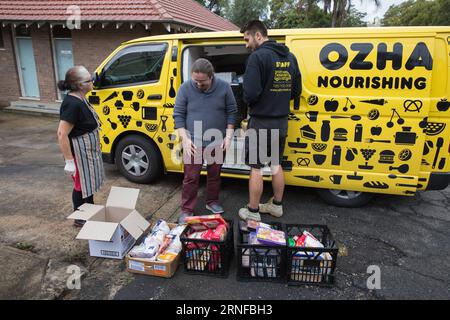 (160729) -- SYDNEY, 29. Juli 2016 -- Aktenfoto vom 8. Juli 2016 zeigt die Mitarbeiter von OzHarvest Alex Hemmer (R) und Dennys Vergara (C), ein Fallmanager im Foundation House in Sydney, das Lebensmittel abholt, in Sydney, Australien. OzHarvest fungiert als Vermittler, der überschüssige Lebensmittel aus über 2.000 Cafés, Bäckereien und Supermärkten an mehr als 800 Wohltätigkeitsorganisationen in ganz Australien abholt und liefert, die den Bedürftigsten des Landes helfen. Die Australier selbst werfen jährlich bis zu 10 Milliarden australische Dollar (7,49 Milliarden US-Dollar) aus, aber die Benachteiligten des Landes gehen nach wie vor an hu Stockfoto