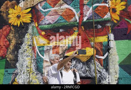 (160731) -- RIO DE JANEIRO, Juli 31,2016 -- Menschen nehmen Selfies vor einem riesigen Graffiti-Gemälde auf dem Olympic Boulevard in Rio de Janeiro, Brasilien, 31. Juli 2016. Der brasilianische Graffiti-Künstler Eduardo Kobra beendete das Gemälde Tage vor der Eröffnung der Olympischen Spiele in Rio 2016. Das Kunstwerk ist fast 3.000 Quadratmeter groß und zeigt einheimische Gesichter aus fünf Kontinenten.) (SP)BRASILIEN-RIO DE JANEIRO-OLYMPICS-GRAFFITI-GEMÄLDE WuxWei PUBLICATIONxNOTxINxCHN 160731 Rio de Janeiro Juli 31 2016 Prominente nehmen Selfies vor einem riesigen Graffiti-Gemälde AUF DEM Olympic Boulevard in Stockfoto