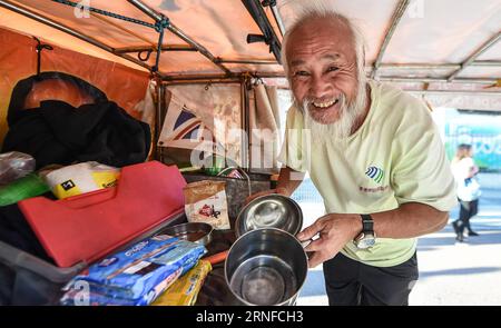 (160731) -- RIO DE JANEIRO, 31. Juli 2016 -- Chen Guanming zeigt sein Essen in seinem Dreirad in Rio de Janeiro, Brasilien, 31. Juli 2016. Der chinesische 60-jährige Bauer Chen Guanming fuhr nach Rio de Janeiro, um seine 3. Teilnahme an den Olympischen Spielen zu feiern. (SP)BRASILIEN-RIO DE JANEIRO-OLYMPICS-CHINESISCHE FAMER-RIKSCHA-FAHRT WangxHaofei PUBLICATIONxNOTxINxCHN 160731 Rio de Janeiro Juli 31 2016 Chen zeigt sein Essen in seinem Dreirad in Rio de Janeiro Brasilien Juli 31 2016 der chinesische 60-jährige Farmer Chen radelte nach Rio de Janeiro, um seine 3. Teilnahme an den Olympischen Spielen SP zu feiern Brasilien Olympische Spiele in Rio de Janeiro CH Stockfoto