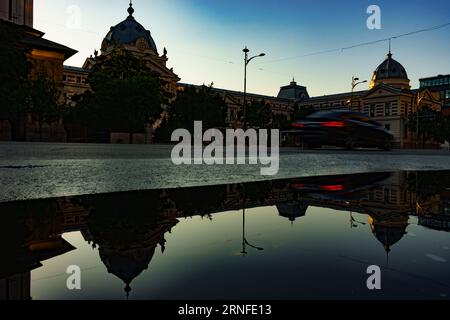 Bukarest, Rumänien - 14. August 2023: Blick auf das Coltea Hospital, reflektiert in einer Pfütze, erbaut zwischen 1867-1888 vom Architekten Joseph Schiffler, auf dem ru Stockfoto