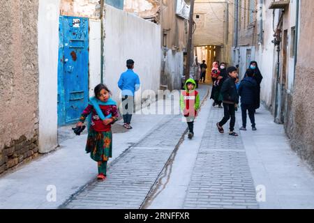 Shiraz, Iran – 31. Dezember 2022: Eine junge iranische Frau im Kopftuch und ihr Sohn und ihre Tochter spielen draußen Stockfoto