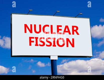 Symbol für Kernspaltung. Konzeptworte Kernspaltung auf wunderschöner weißer Plakatwand. Wunderschöner blauer Wolkenhintergrund. Geschäftswissenschaft Nukleartechnik Stockfoto