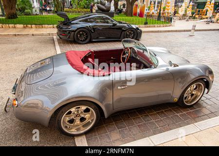 Ein neuer Porsche 911 im Hintergrund mit einem makellosen Vintage-Porsche vor der Hôtel Eremitage in Monte-Carlo, Monaco, Frankreich Stockfoto