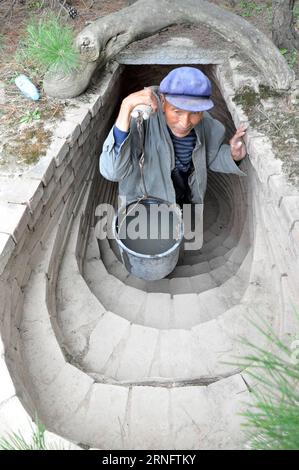 (160824) -- TONGWEI, 24. August 2016 -- Xu Zhiqiang, 68, transportiert Wasser, um durch einen selbstgebauten Tunnel zu gehen, um Bäume zu bewässern, die auf dem Berg im Dorf Zhangchuan im Tongwei County, nordwestchinesische Provinz Gansu, am 23. August 2016 gepflanzt wurden. Xu Zhiqiang und sein Zwillingsbruder Xu Zhigang haben 48 Jahre lang freiwillig Bäume auf kargen Hügeln auf dem Loess Plateau gepflanzt. Mehr als 350 mu (23 Hektar) karges Land haben sich mit ihrer Plantage von über 80.000 Bäumen und Blumen grün gemacht. Die Bemühungen der Brüder tragen nicht nur dazu bei, natürliche Schönheit zu schaffen, sondern verbessern auch die lokale ökologische Umwelt. Guo Ga Stockfoto