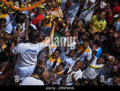 (160825) -- MUMBAI, 25. August 2016 -- Ein Vertreter von Jugendlichen, die sich dem Bau von Menschenpyramiden anschließen, bricht den Tonquark, der während der Feier des DAHI Handi Festivals im Viertel Dadar in Mumbai, Indien, am 25. August 2016 in der Luft hängt. Dahi Handi ist ein indisches Festival zur Geburt des hinduistischen Gottes Lord Krishna. Basierend auf der Legende des Kindergottes Krishna, der Butter stiehlt, besteht das Festival darin, eine menschliche Pyramide zu bauen und einen mit Quark gefüllten Erdtopf zu brechen, der in der Höhe gebunden ist. ) (cl) INDIA-MUMBAI-DAHI HANDI FESTIVAL-CELEBRATION BixXiaoyang PUBLICATIONxNOTxINxCHN 160825 Mumba Stockfoto