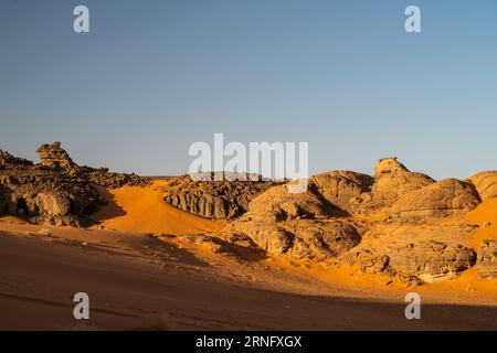 Blick in die Sahara Wüste von Tadrart rouge tassili najer in Djanet City, Algerien. Farbenfroher oranger Sand, felsige Berge Stockfoto